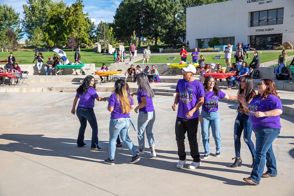 students enjoying dancing at the fiesta at sunset celebration in learning commons plaza